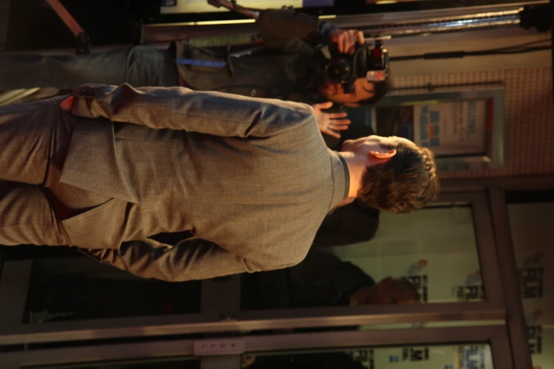 a man in a gray suit walking out of a building