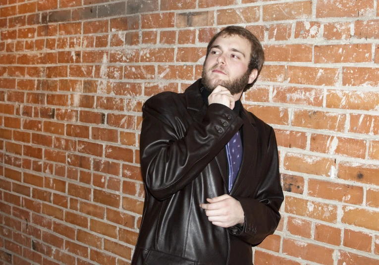 a man is wearing a leather coat and tie