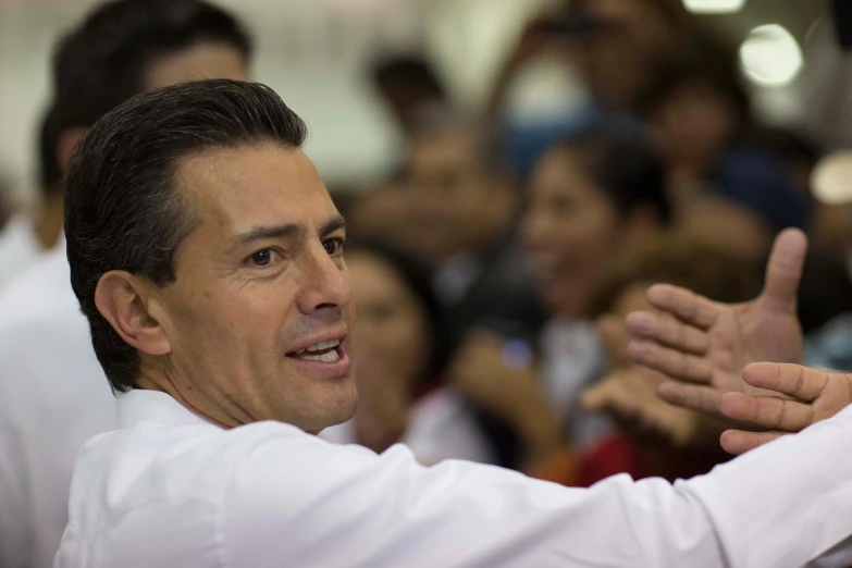 a man in a white shirt gesturing to people