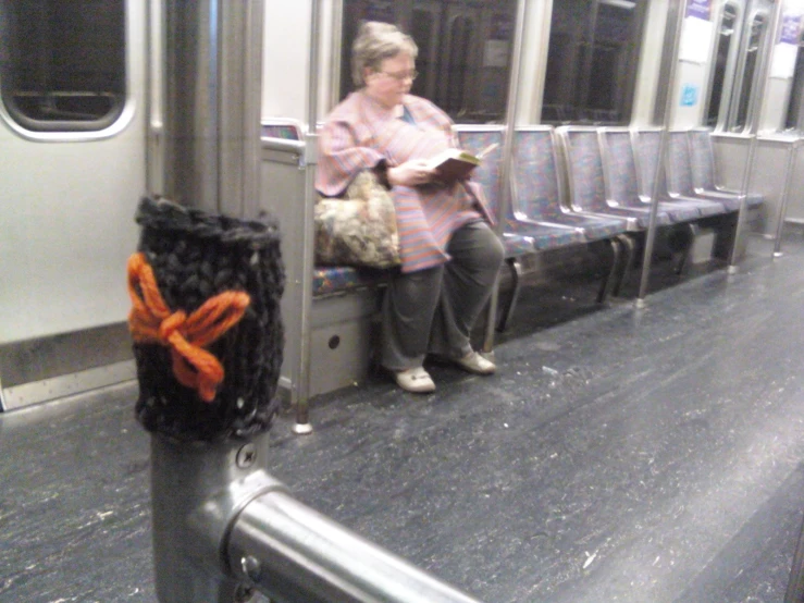 an older woman is sitting on a train