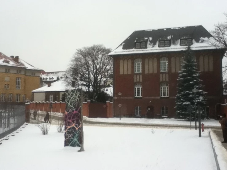 a building with some trees on the other side and snow on the ground