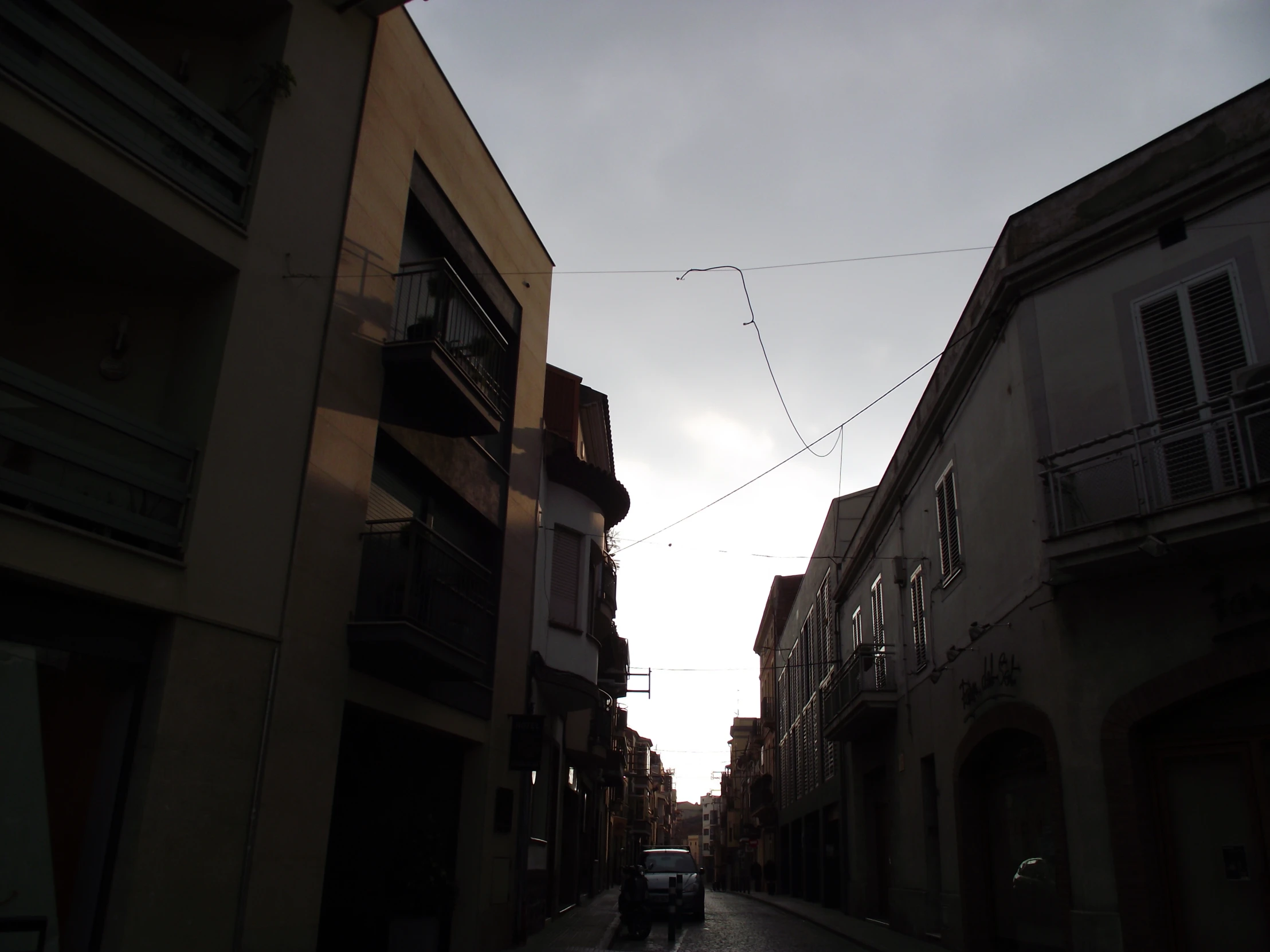 a car is parked in an alley of buildings