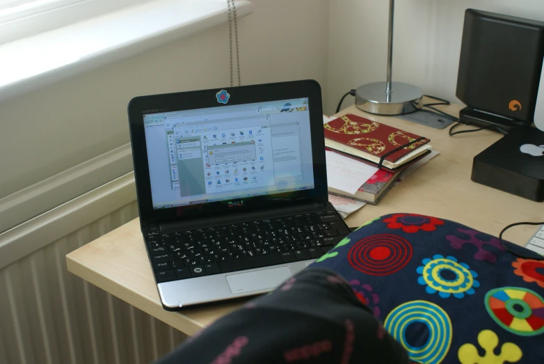 an open laptop computer sitting on top of a wooden desk