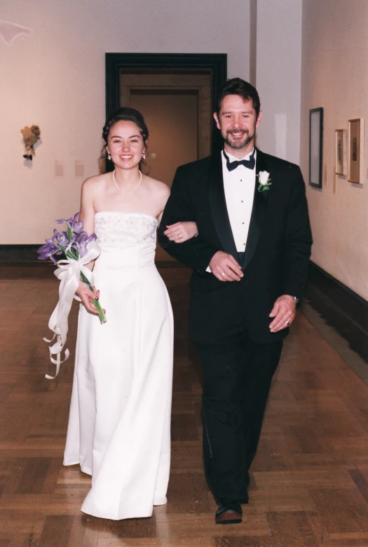 a bride and groom walking down a hallway