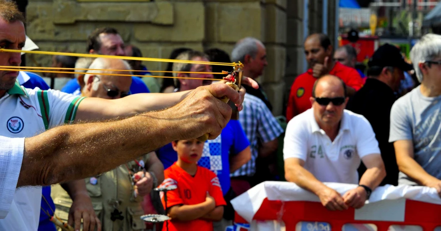 a man holds out his string to an individual at a parade