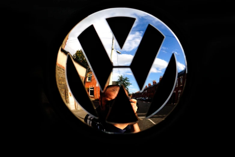 the person is walking in front of a vw sign