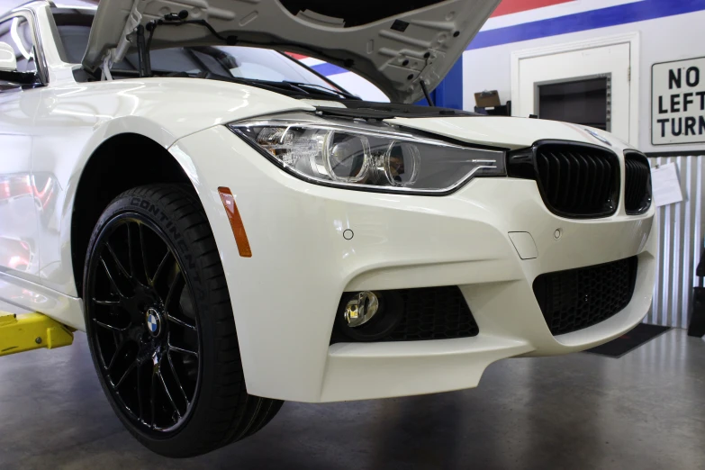 the car in the garage is white with black spokes