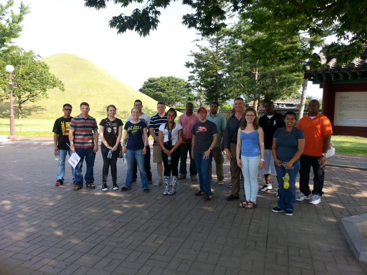 a group of young men and women stand together outside