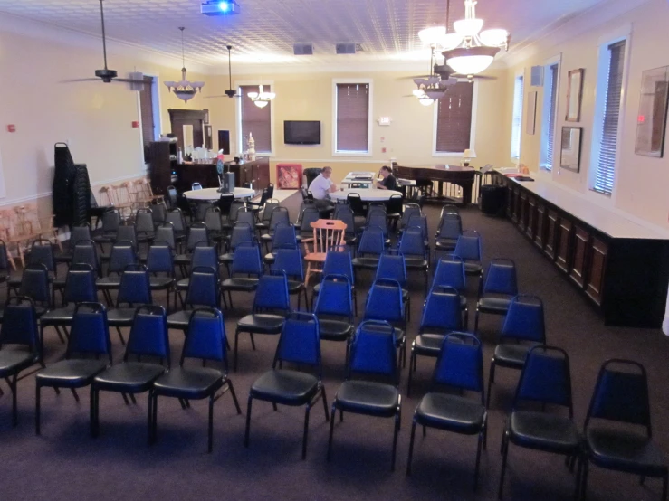 a large room with blue chairs in front of windows