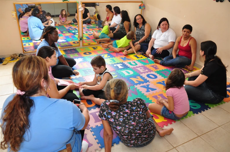 a group of children sitting on a colorful rug