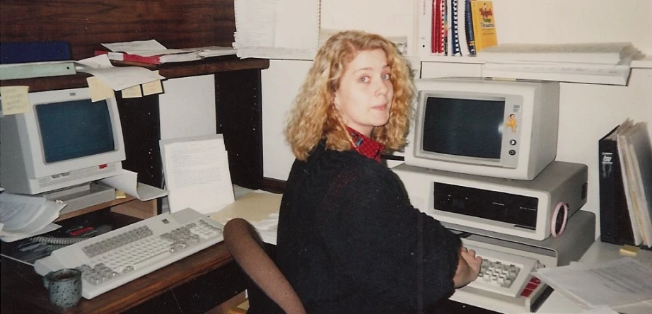 the woman in a black shirt is sitting at her computer