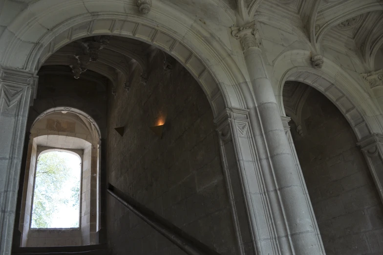 there is a stairway in the building with stone walls