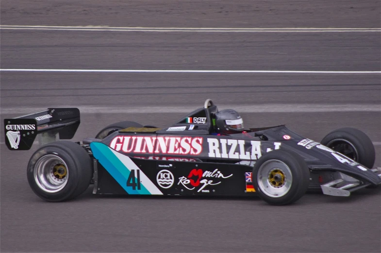 a formula race car on a racetrack next to another