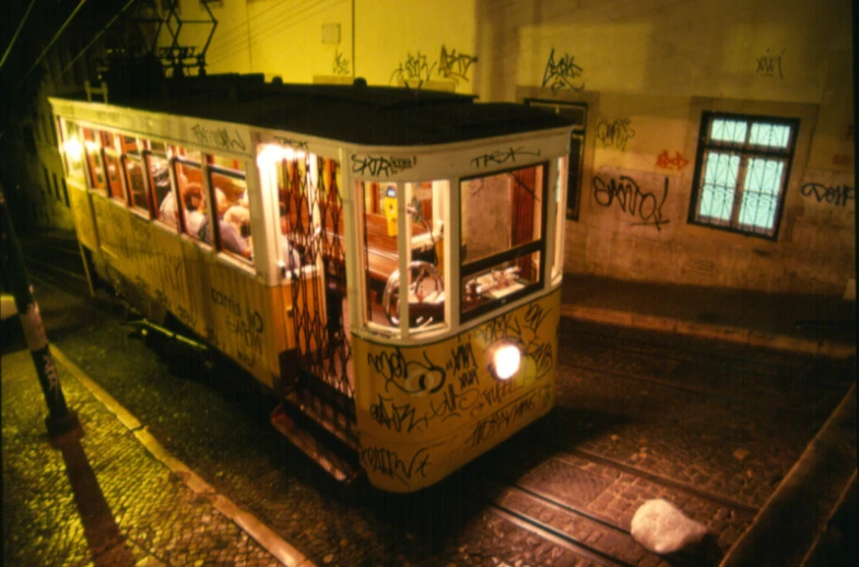 an old trolley with graffiti on it at night