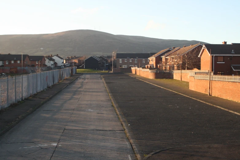 the empty road is beside some brown brick buildings