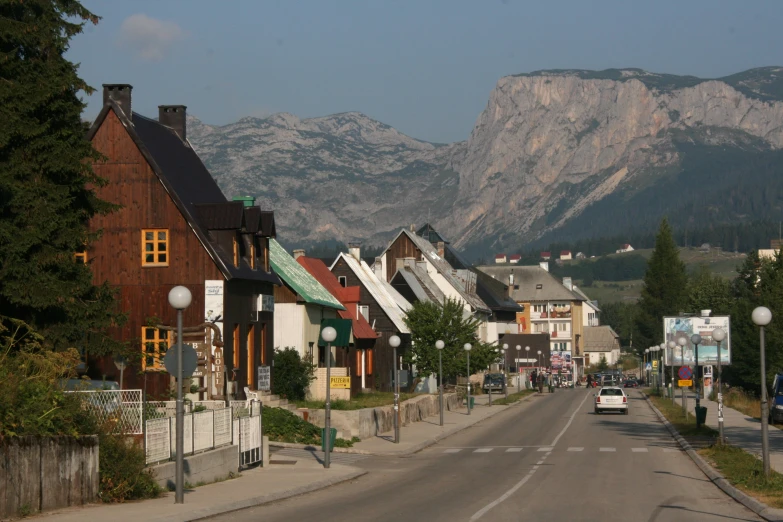 a street scene with many buildings and mountains in the background