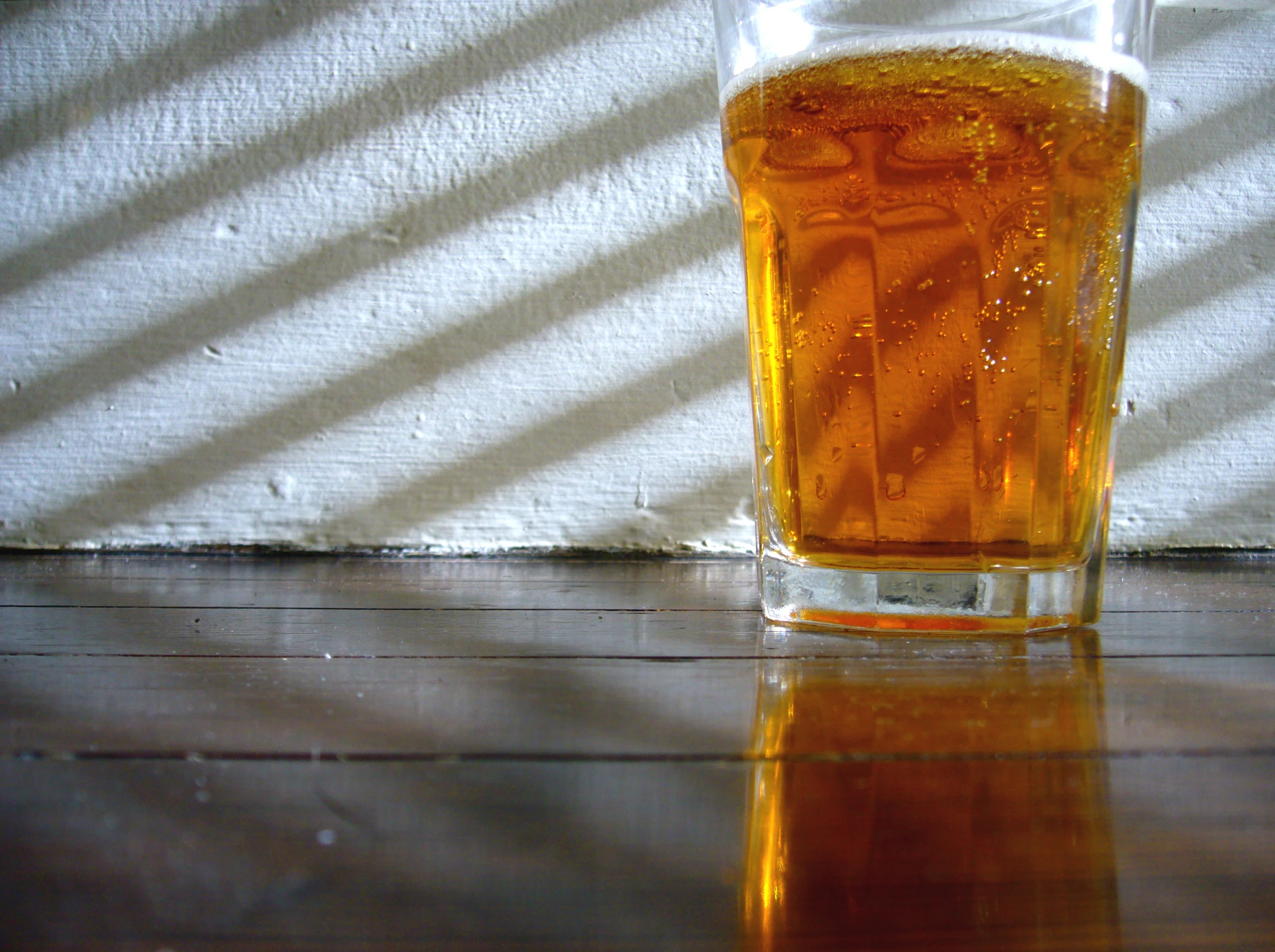 glass of beer sitting on top of a table