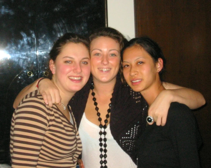 three women in striped shirts are posing for a picture