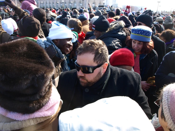 a crowd of people standing around each other wearing hats