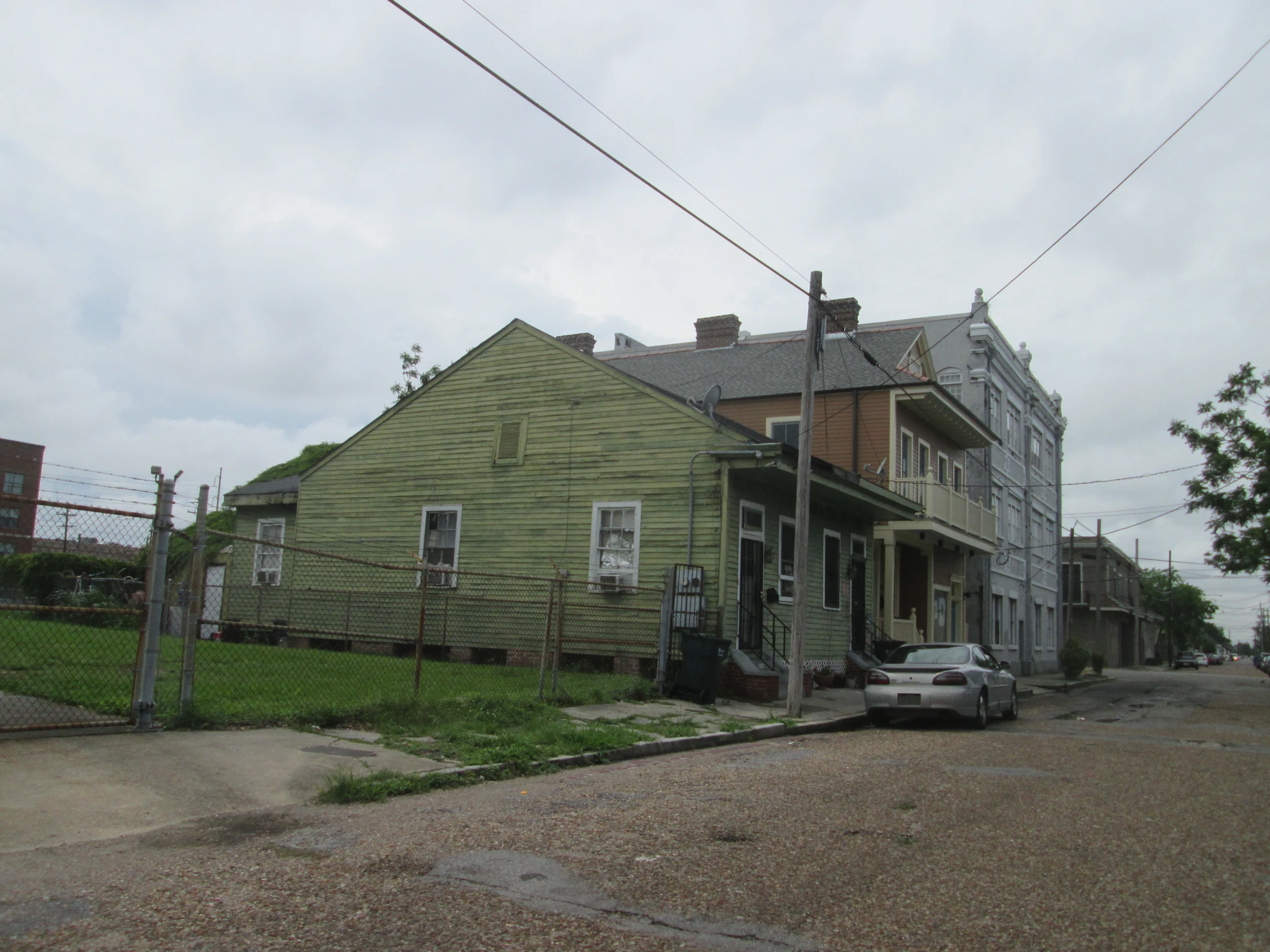 an old abandoned home with some cars parked in front