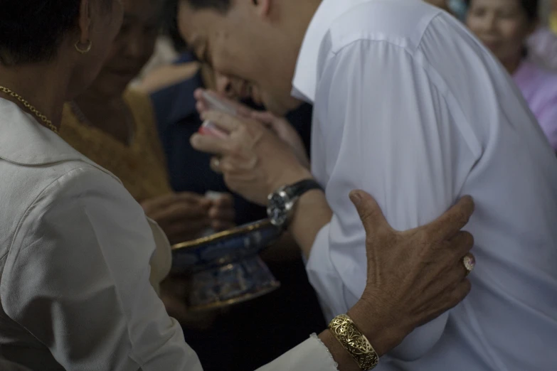 two men are talking while a woman claps her hands