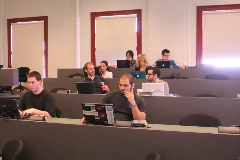 people working on laptop computers in an auditorium