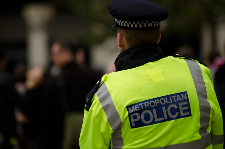 metropolitan police officer walking down the street in neon clothing