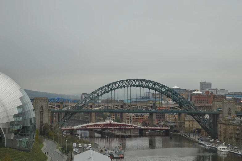 the view of an arched bridge, next to another large city