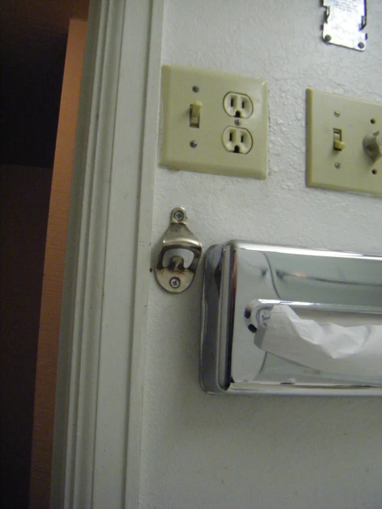 a silver door handle is shown with three light switches