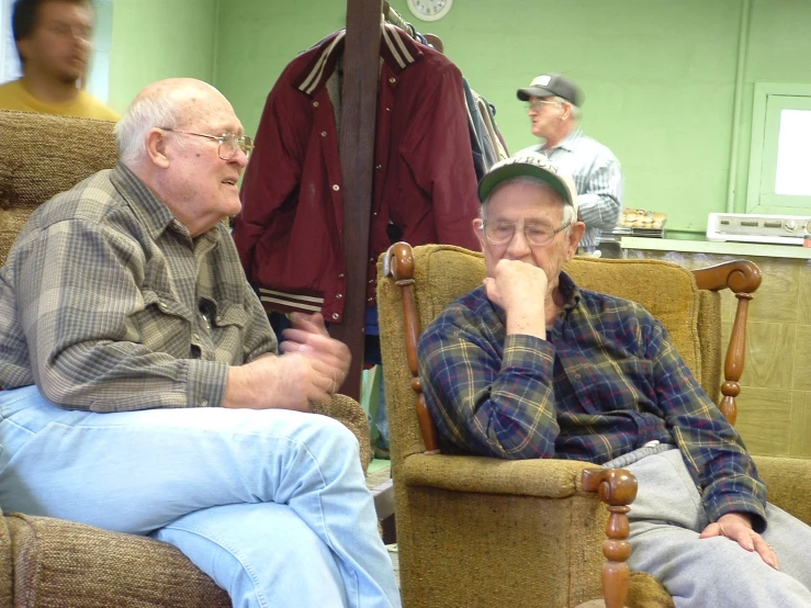 an elderly gentleman sits in a chair with his foot on the table