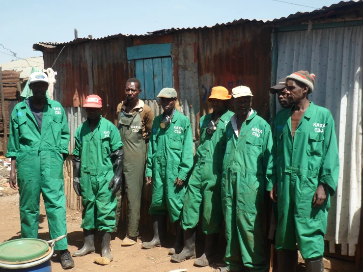 a group of men in green clothes are posing