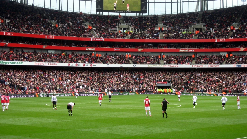 a large crowd watches the soccer players on the field