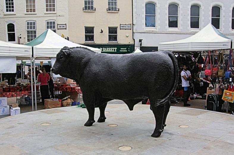 a big bull standing on the sidewalk in the middle of a city