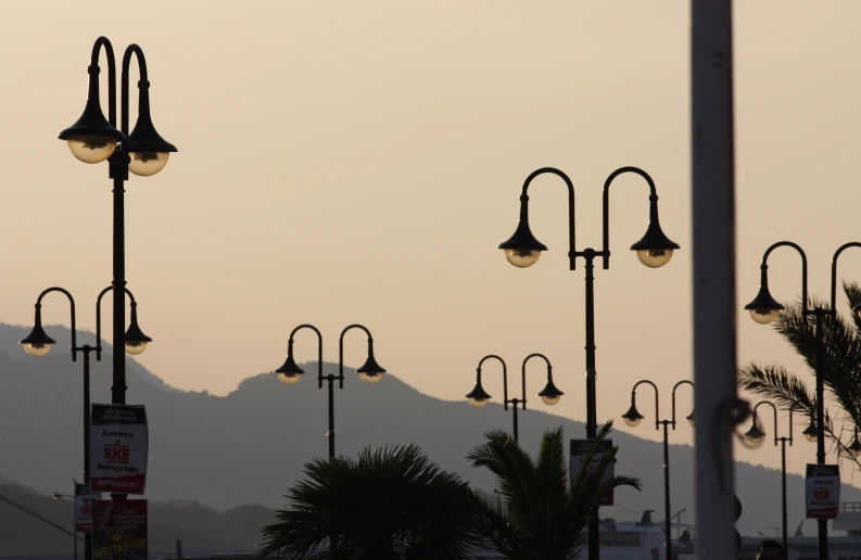 there are street lights and street lamps with mountain in background