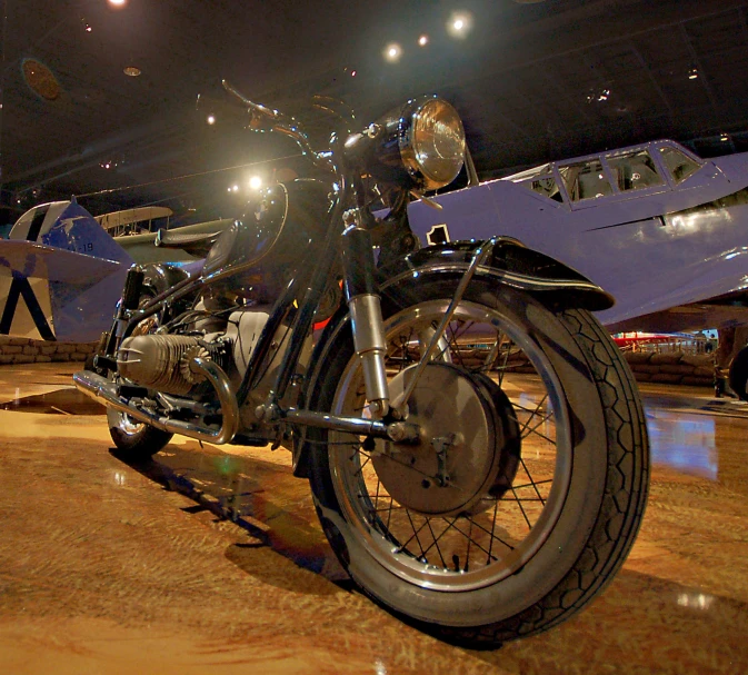 motorcycle on display at show with planes in the background