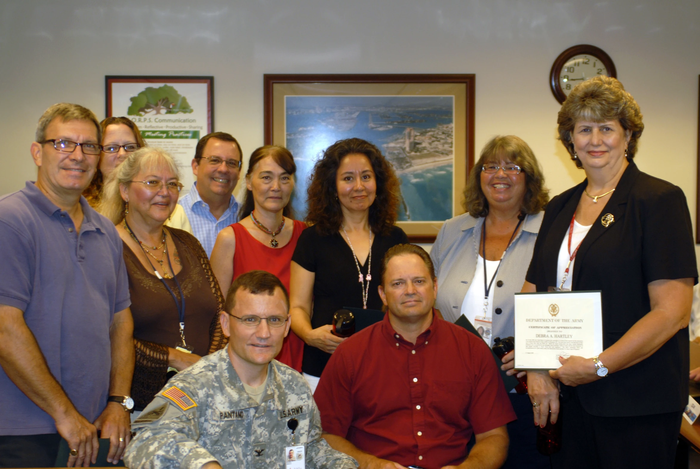 a group of people pose with a plaque