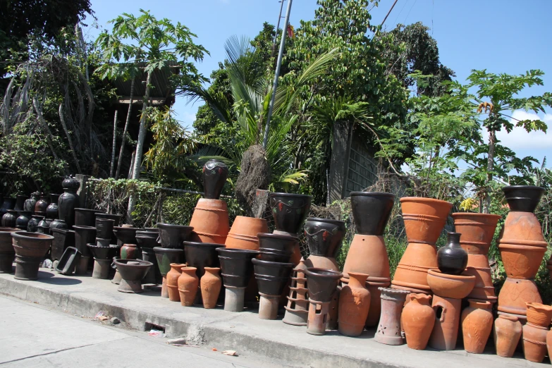 rows of large, brown vases on display near tree's