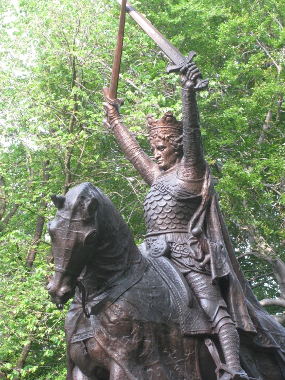 a bronze statue on top of a horse holding a sword
