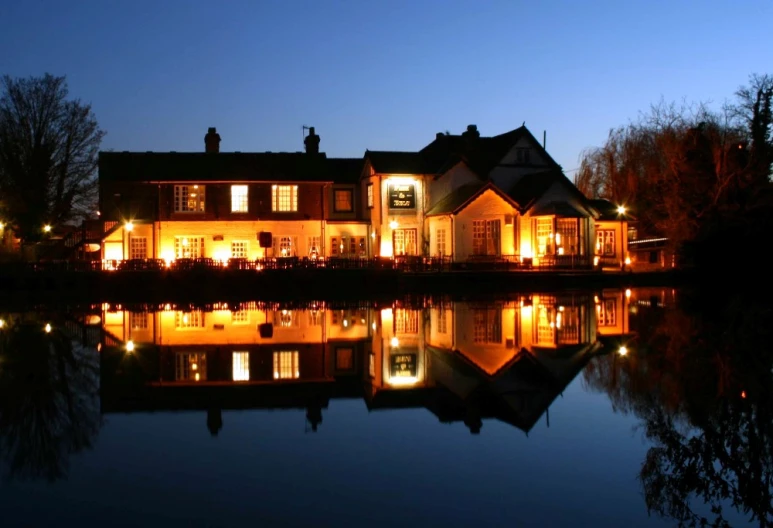 a large house that is standing next to a pond