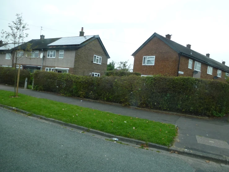 a street with cars parked and a row of houses