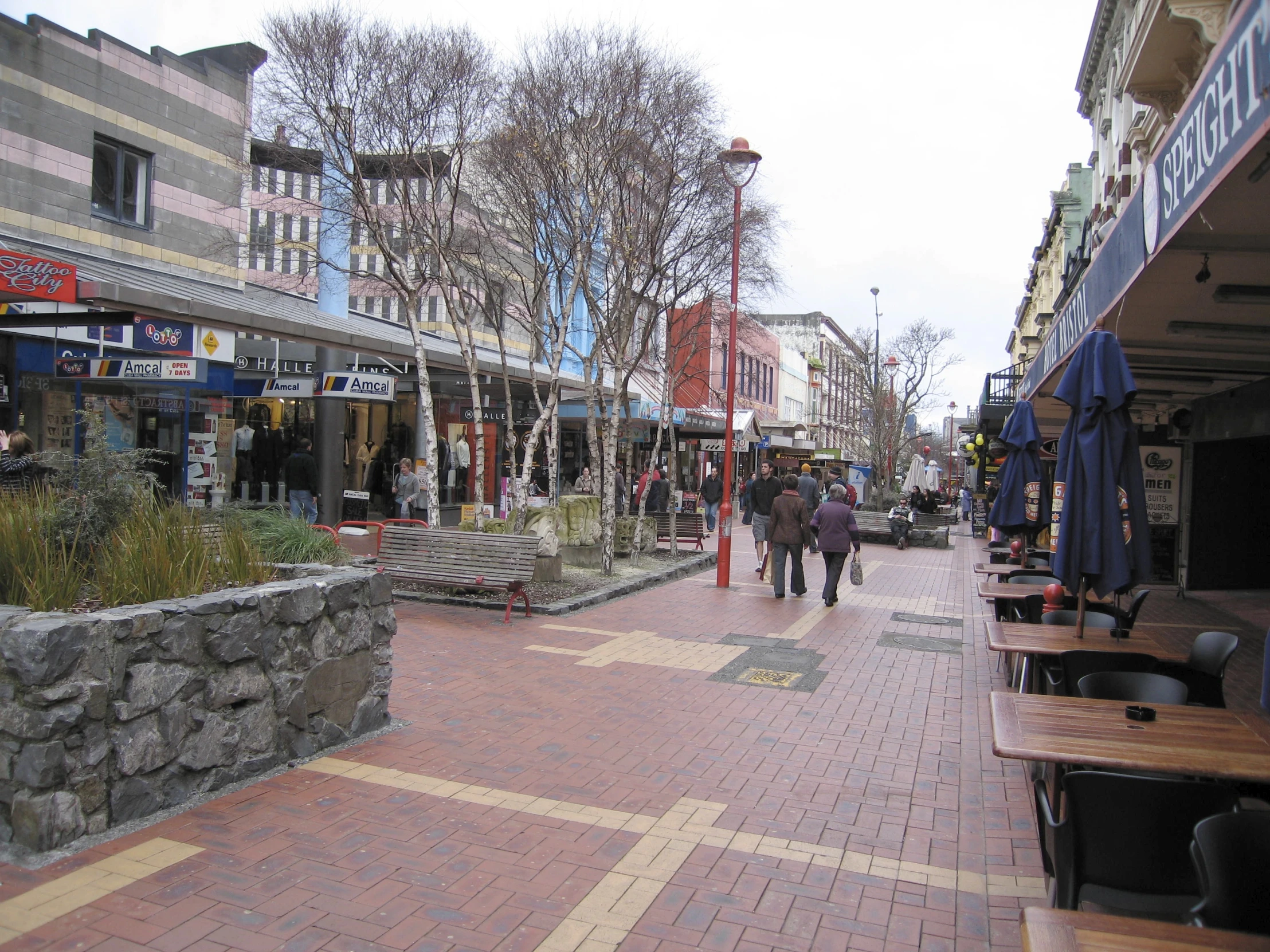 a couple walking down a street next to shops