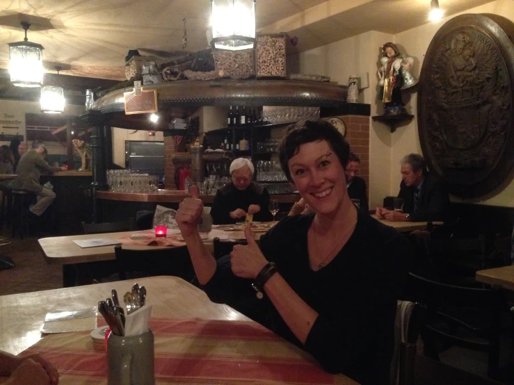 a women who is giving the peace sign at a restaurant
