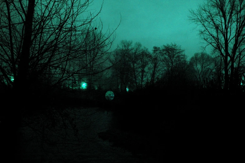 a green and black scene with a street light and trees