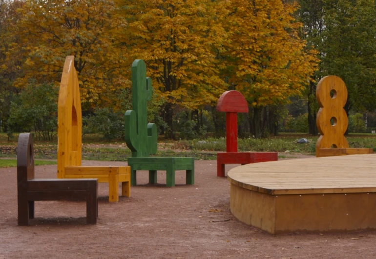 colorful sculptures are set up on the ground near a wooden table