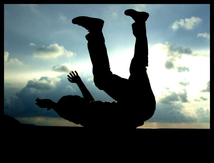 silhouette of a person doing a hand stand