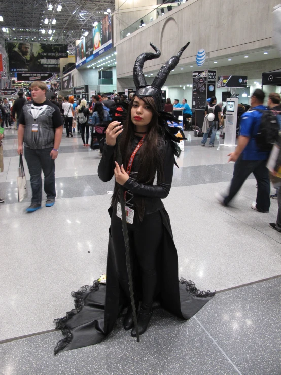 a person dressed up as a demon in the middle of an indoor mall