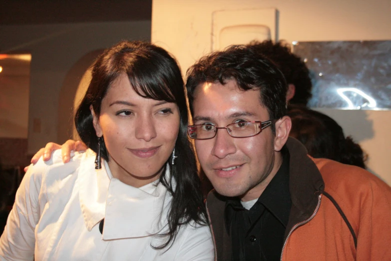 man with eye glasses standing next to a smiling woman