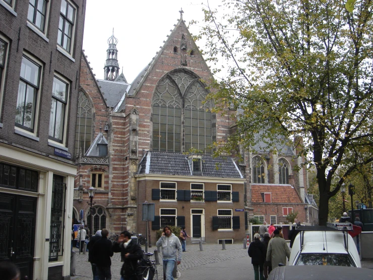 people walking by on a narrow street with old building