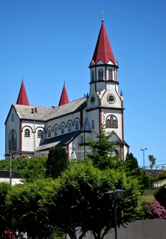 the tall tower on the church has a cross