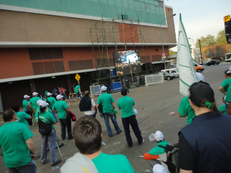 people in green shirts are at a street event